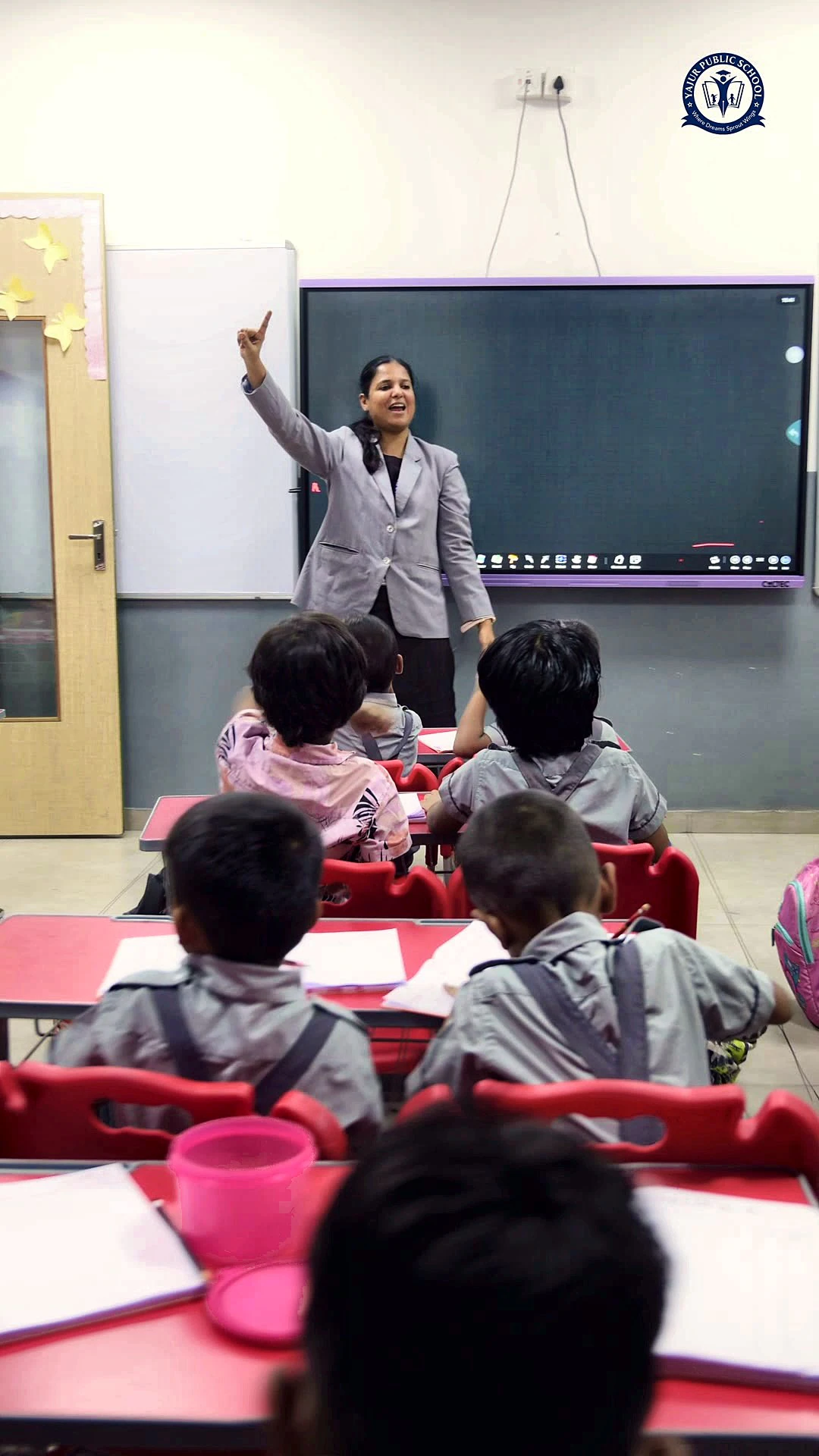 A Yajur teacher leading her class at the smart board