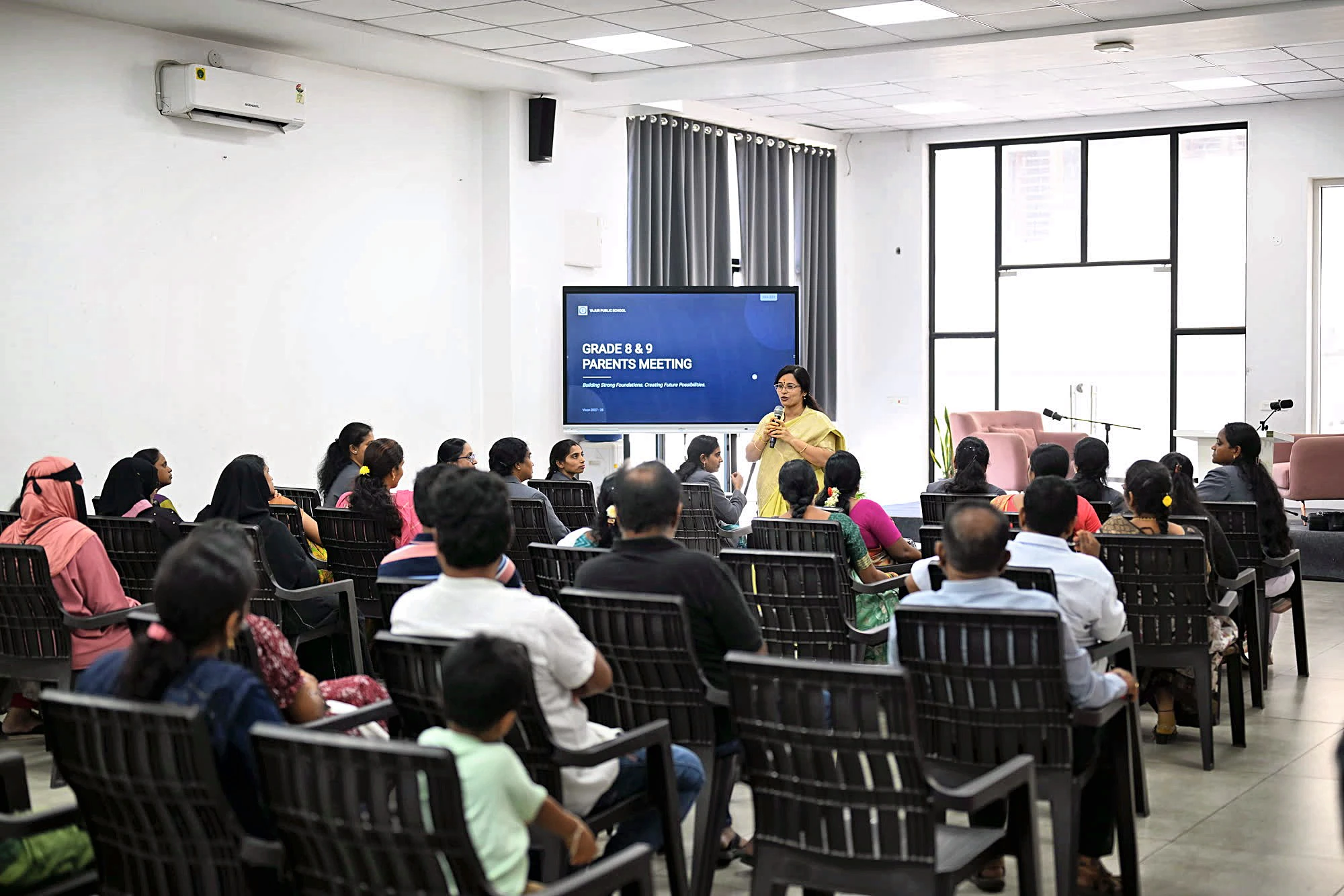 Families gathered in the hall for a Yajur parents' meeting