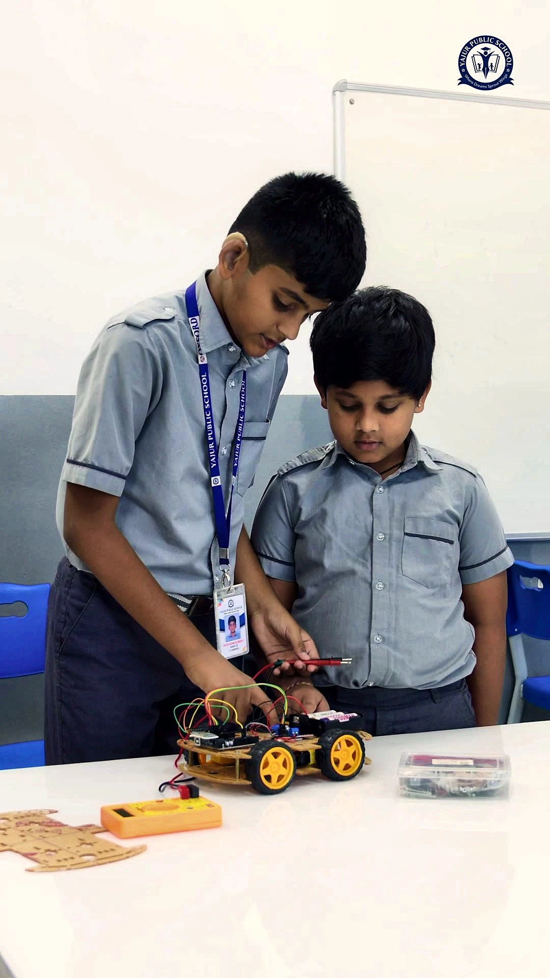 Yajur students building a robot car in the robotics lab