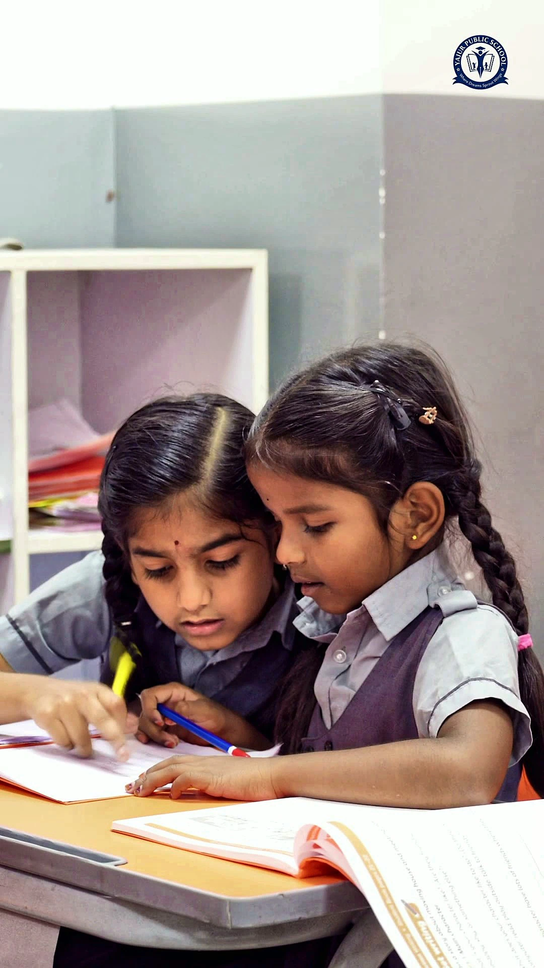 Two primary students working together in one notebook