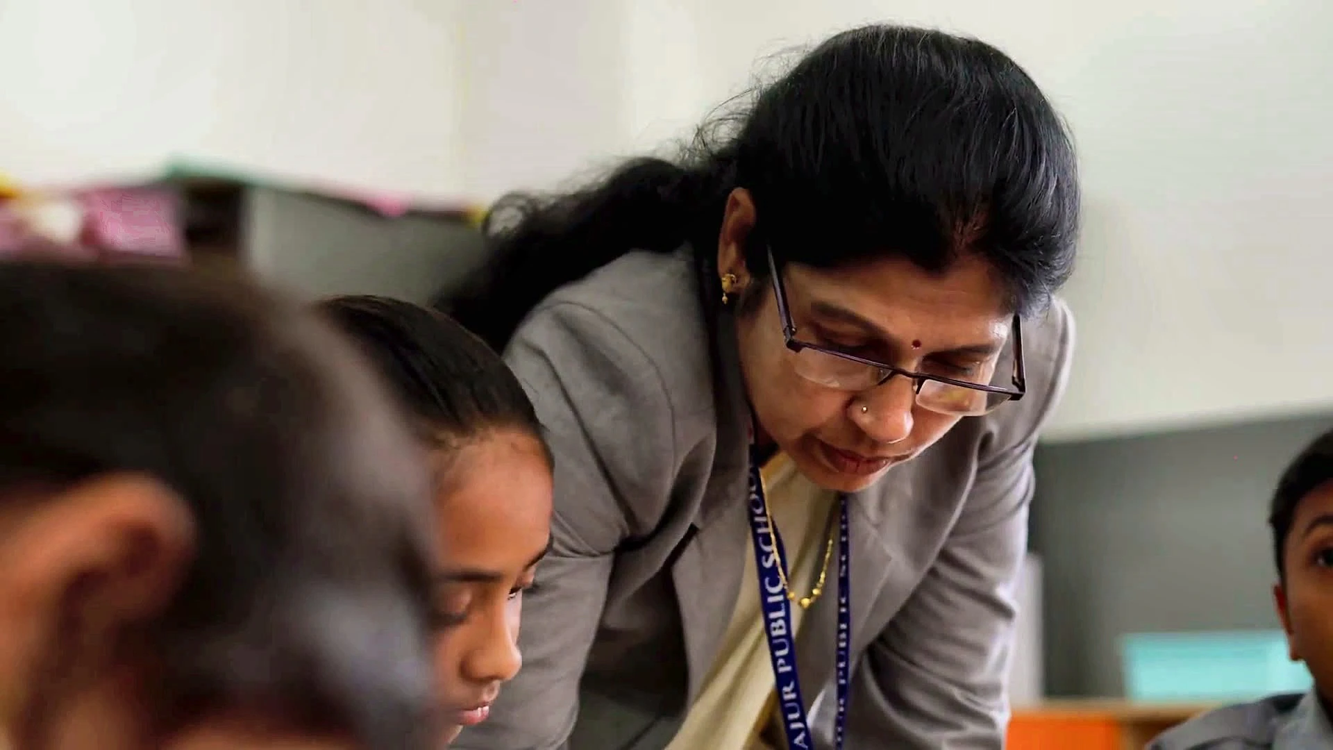 A Yajur teacher guiding a student through her work
